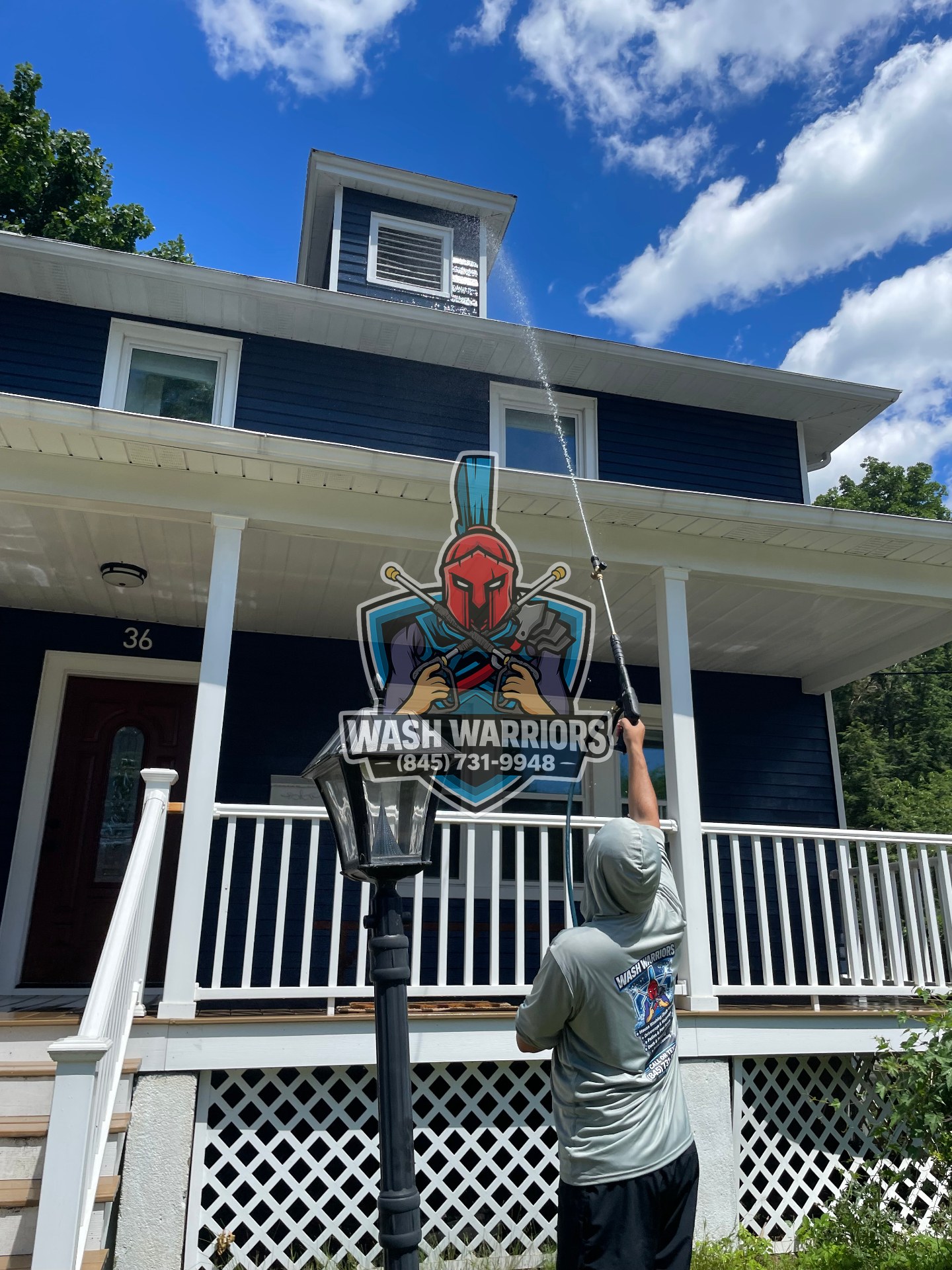 Wash Warriors technician soft washing a three-story home exterior